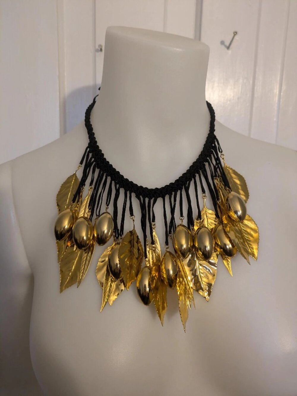Necklace black cord with dangling gold metal leaves, and ovals